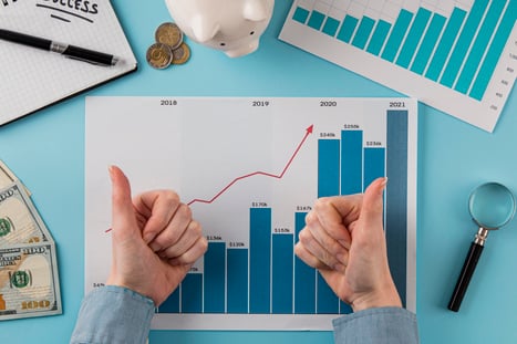 top-view-business-items-with-growth-chart-hands-giving-thumbs-up