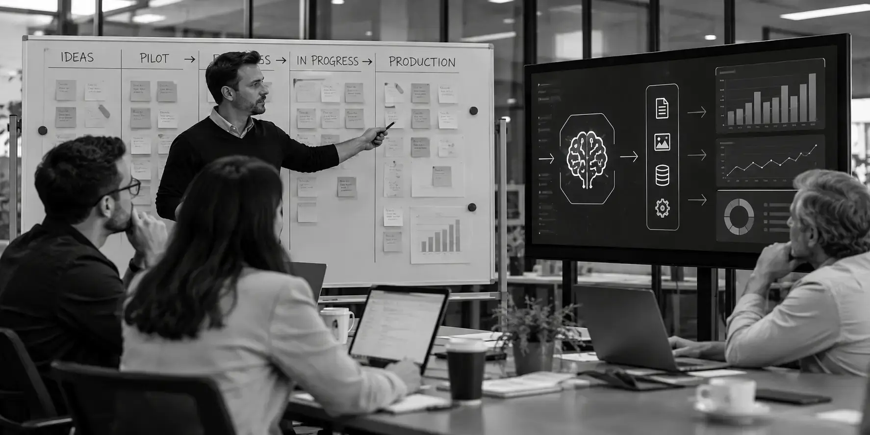Black-and-white image of enterprise professionals collaborating in a meeting, reviewing an AI workflow dashboard